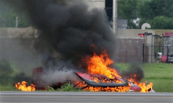 Remains of a fiery crash that killed a stunt pilot who couldn’t pull out of a downward spiral are seen during the Kansas City Air Expo Air Show at the Kansas City Wheeler Downtown Airport, Saturday, in Kansas City, Mo. 